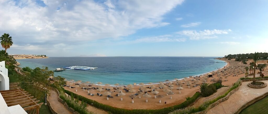 Zátoka Coral Bay v Sharm El Sheikhu: písečné pobřeží, palmy a Rudé moře